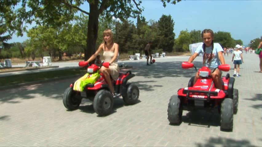 Two young girls go for a drive on ATVs