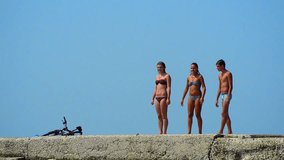 Summer Sea, Ocean, Pool Fun - Stock Video. Three teens jumping from concrete pier