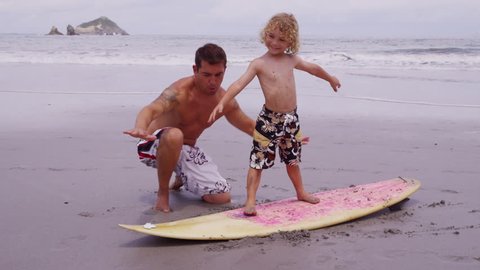 Father and son at beach with surfboard, Costa Rica Arkivvideo