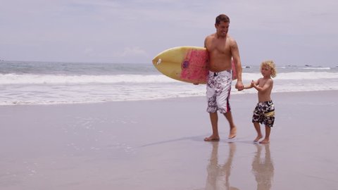 Father and son at beach with surfboard, Costa Rica: film stockowy
