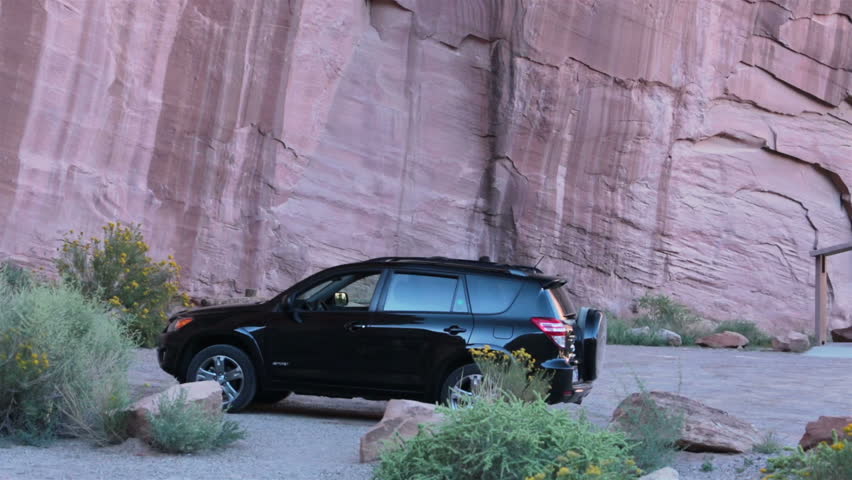 Woman by car Rock Indian Pictograph Utah. Buckhorn Draw Panel is ancient rock art, located in the San Rafael Swell in central Utah. Old Spanish trail and American Indian travel route. Fremont culture.