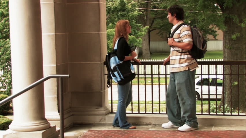 Students meet outside the library on a college campus.