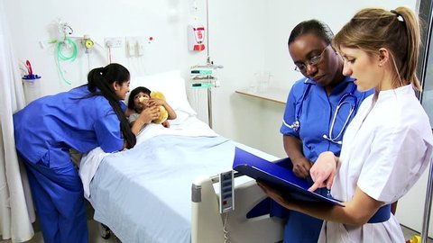 Multi-ethnic nursing staff provides bedside support to a cute young child hospital patient, videoclip de stoc