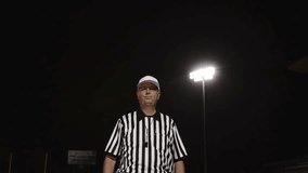 A football referee gives a holding penalty hand signal