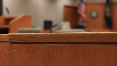 A wooden half door swings in a courtroom.