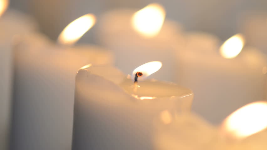 Close Shot Of A White Candle Burning With Bright Candle Light. Few Candles