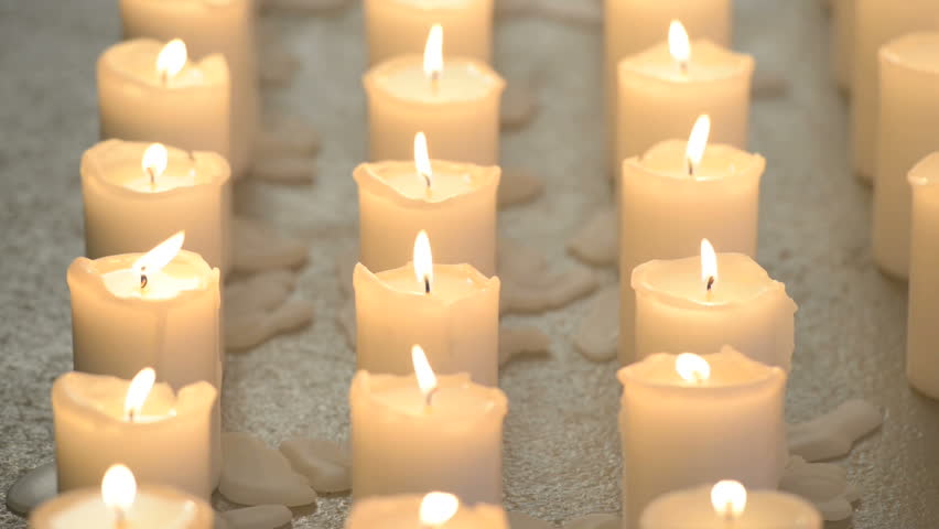 Fifteen White Candles Aligned Vertically Burning With Bright Flames