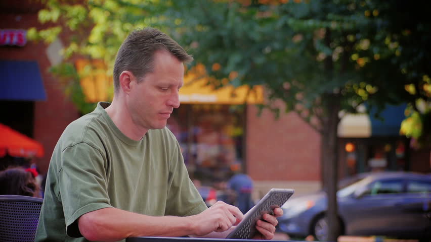 A man uses a tablet computer outside at Market Square in downtown Pittsburgh Pennsylvania. 