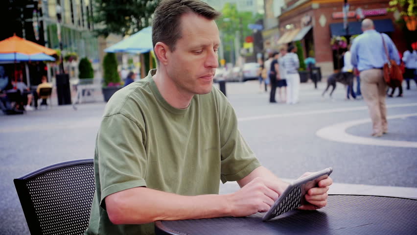 A man uses a tablet computer outside at Market Square in downtown Pittsburgh