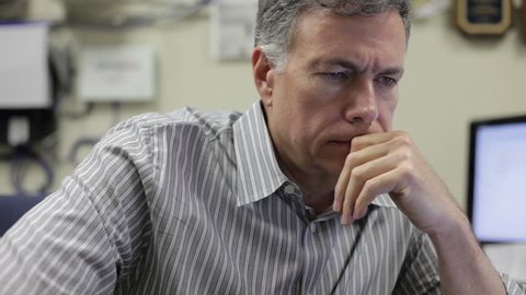A pensive mature man sitting in his office at work.