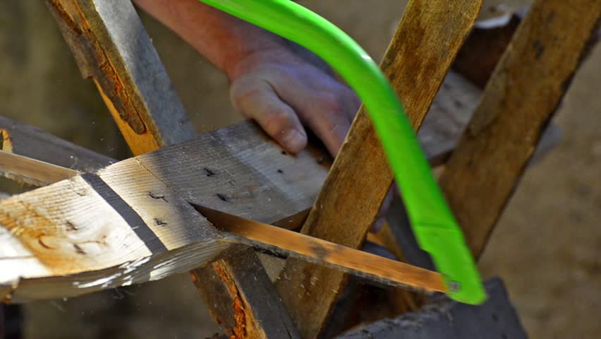 HD: Carpenter Sawing the Wood - Stock Video close up. Man Uses Manual Hand Saw