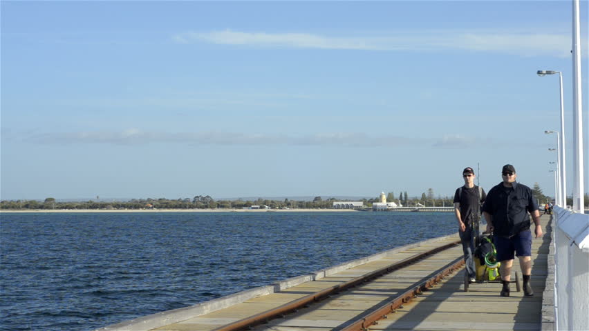 BUSSELTON, AUSTRALIA - NOVEMBER 7 2012: Two fishermen walking out along the