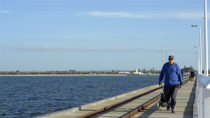 BUSSELTON, AUSTRALIA - NOVEMBER 7 2012: An elderly fisherman walking out along