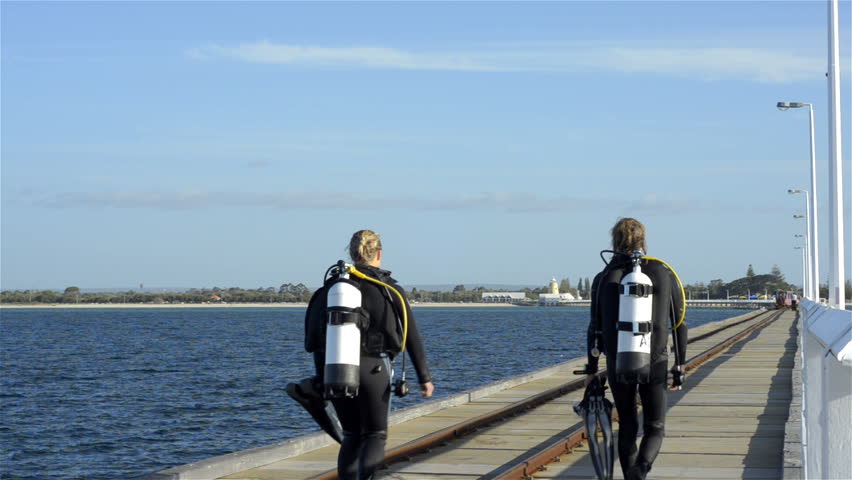BUSSELTON, AUSTRALIA - NOVEMBER 7 2012: Two scuba divers walking back to shore