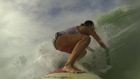 Surfing woman getting a wave in Brazilian beach,  point of view.