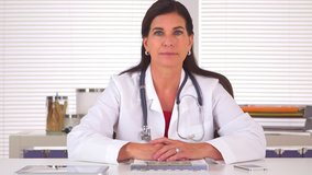 Woman doctor listening to patient and looking at camera