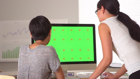 Two Asian businesswomen looking at green screen Arkistovideo