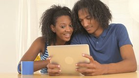 Black couple watching videos on tablet