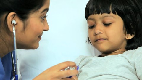 Close up view of a nurse using a stethoscope to listen to the heart rate of a very young female patient in the hospital
