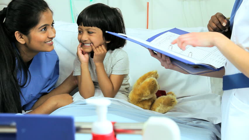 Multi-ethnic female nursing staff discussing treatment for a sick little South Asian girl in the hospital