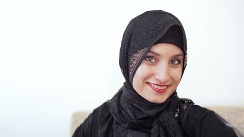 headshot of young millenial teenage muslim girl with grey eyes a hijab headscarf and red lipstick smiling