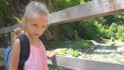 Child on a Bridge Looking to a Spring in Mountains, Tourist in a Trip, Children