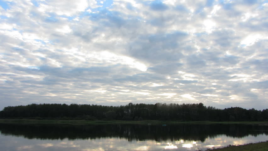 timelapse with evening clouds over lake