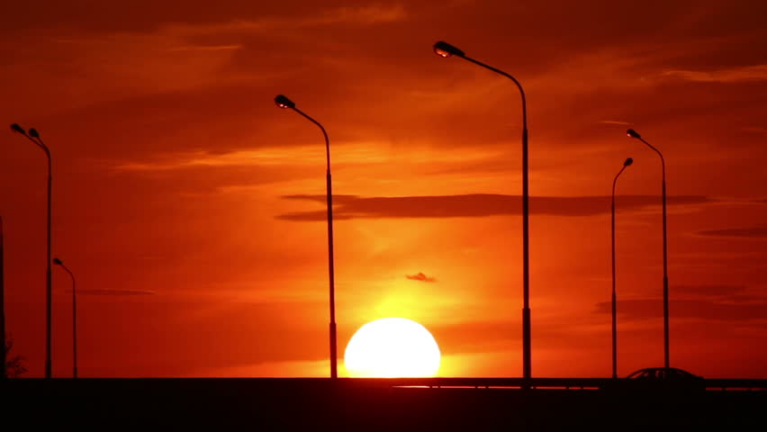 Cars silhouettes on road against sunset