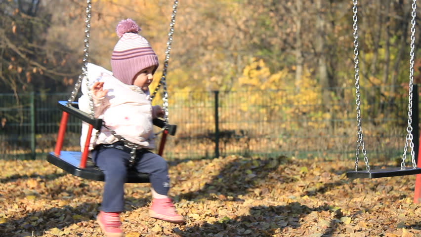 Cute baby on a swing in a park