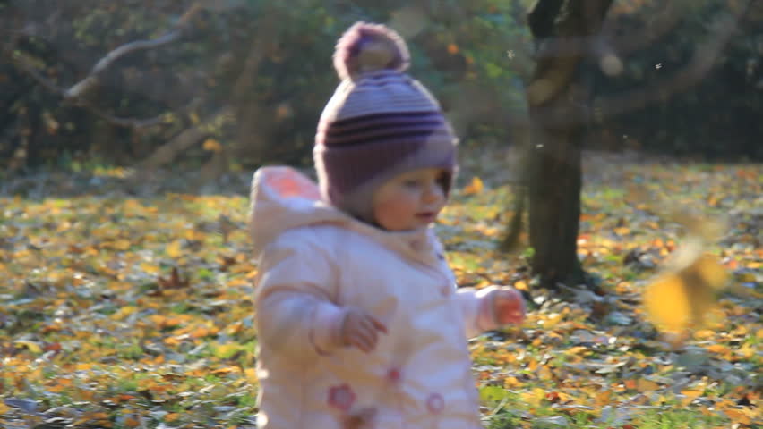 Cute baby walks in parK in autumn