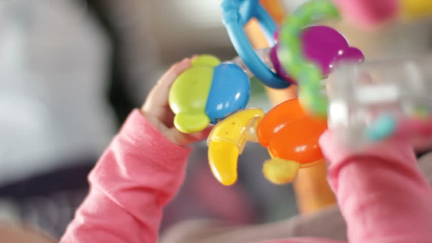 Cute infant plays with rattle
