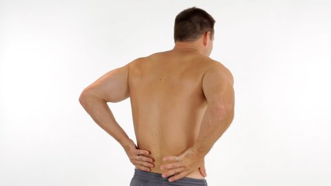 A young muscular man who appears to be experiencing back pain.