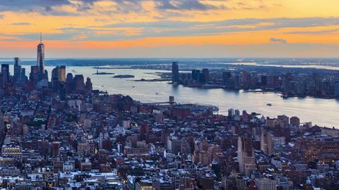 New York City Manhattan aerial skyline. Pan across cityscape panorama. Transition from sunset to night. Timelapse.