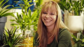 portrait of young hispanic woman working as sales clerk in flower shop, arranging plant and pots and looking at camera smiling - Powered by Shutterstock - Get 15% off with code: PIKWIZARD15