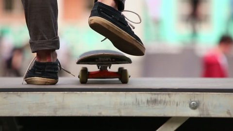 Legs of skateboarder which star ride on board from ramp