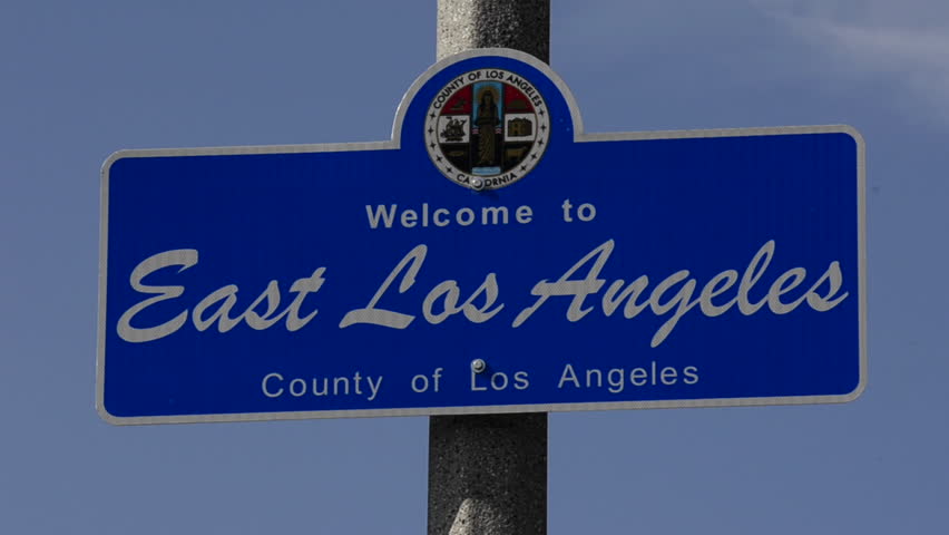 Rack focus on a Welcome to East Los Angeles sign at Belvedere Community Regional Park in East Los Angeles, California.