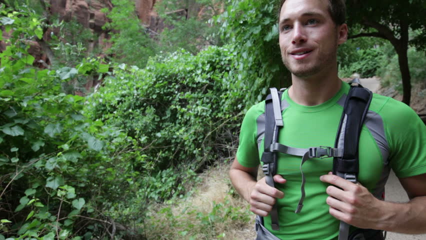 Hiking - hiker mantrekking with backpack on forest path. Young fit man and on hike in Zion Canyon, Zion National Park, Utah, USA.
