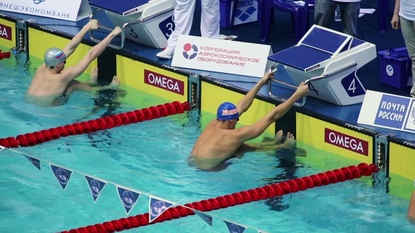 MOSCOW - APR 20: Men jump into water during start of swimming on back in pool at Championship of Russia in Olympic Sports complex on 20 April 2012 in Moscow, Russia