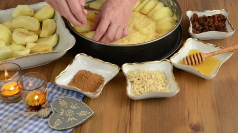Apple pie baking. Spreading apple slices on the pie dough. In addition, ingredients such as honey, cinnamon, sugar, almond slivers  Stock Video