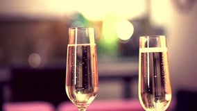 Champagne. Two Glases with Sparkling Champagne Toasting over Holiday Bokeh Blinking Background. Slow motion.
