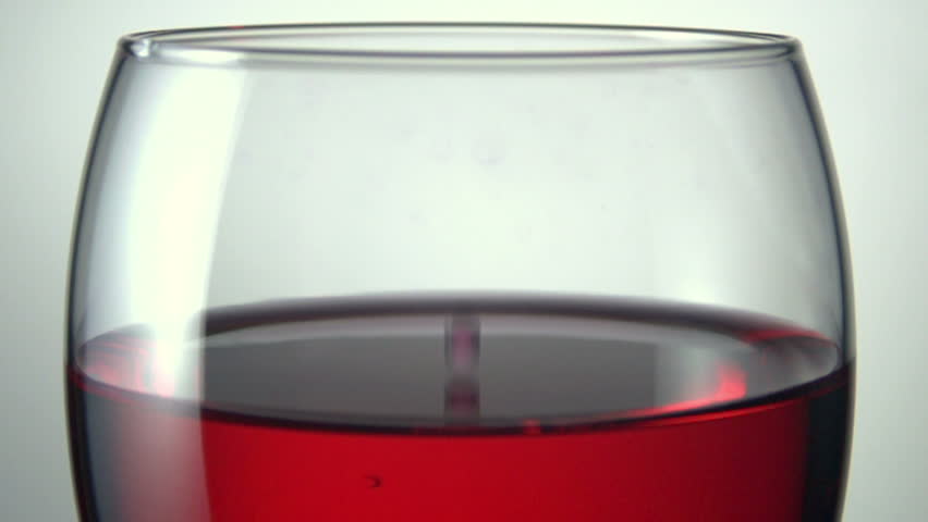 red wine being dropped into glass shot in super slow motion