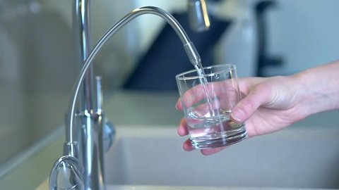 Woman Drinking Fresh Water from the Kitchen Faucet. Glass of fresh Water. Healthy Lifestyle Full HD Video Footage. Slow Motion Dolly Shot