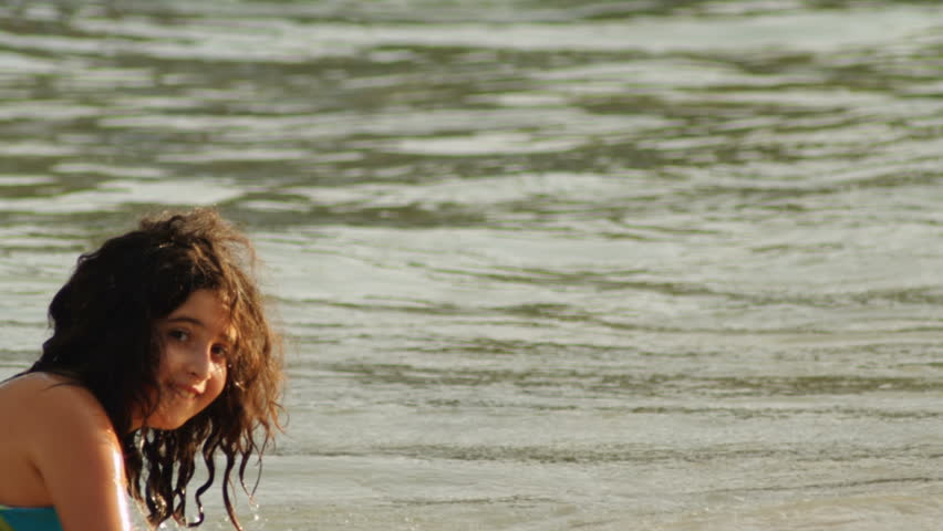 A young girl plays in the waves at the beach