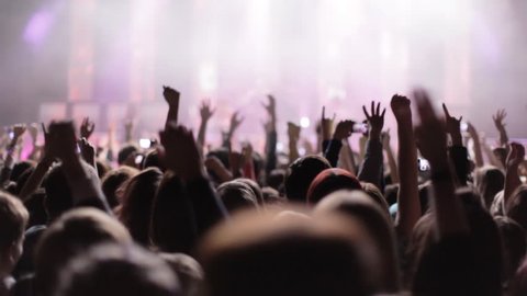 Crowd partying at a rock concert. silhouetted hands and flashing lights.