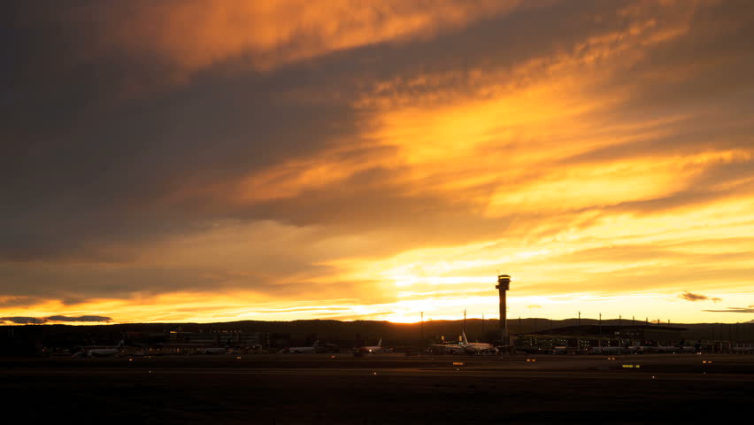 Airport tower in silhouette in a beautiful evening sky time lapse
