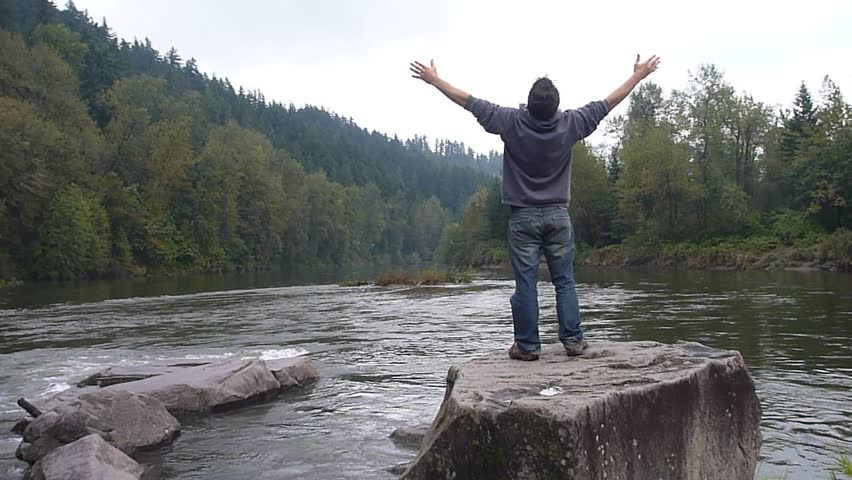 Model released man enjoying river view in Oregon wilderness.