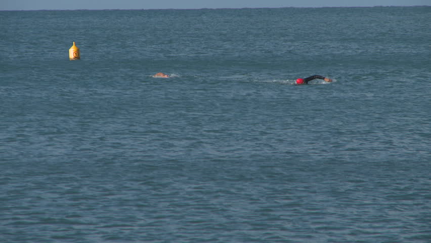Two swimmers head back to shore after a swim in the sea.