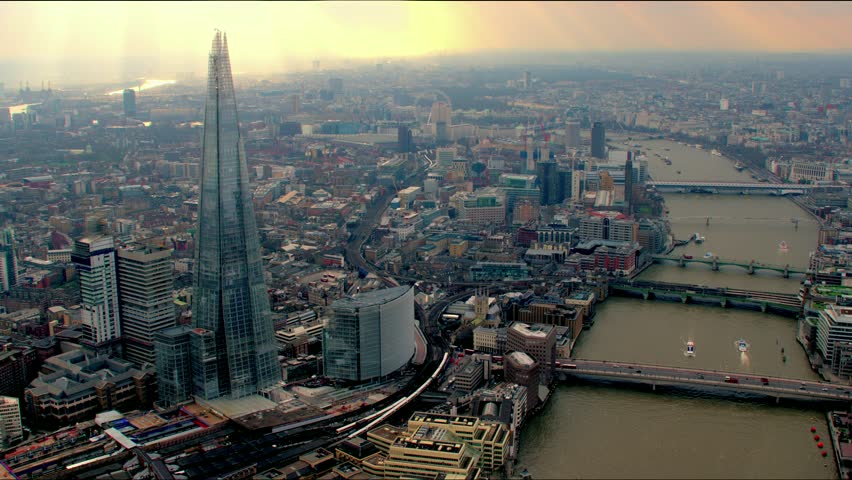 Panoramic aerial shot along the River Thames in Central London, UK. Features The Shard building, bridges and the Millennium Wheel / London Eye in the background.