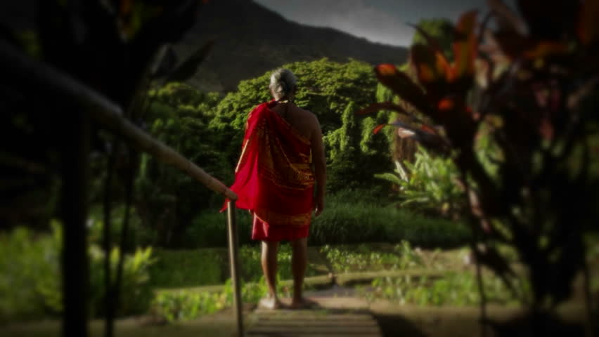 A native man in Hawaii stands in a field and a child suddenly appears next to him.