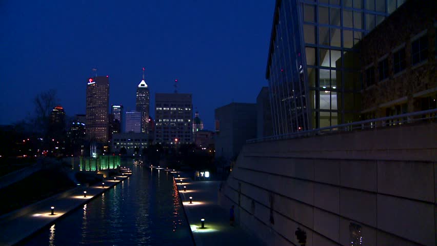 The city of Indianapolis Indiana at night with the White River foreground.